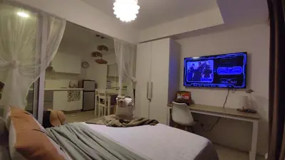 a bedroom with a bed and a tv on a wall at Azure Bali Verde-1Bedroom pool view in Manila