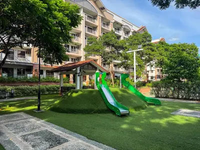 a playground with a green slide in a park at Boutique one-bedroom apartment near airport, business hubs in Manila