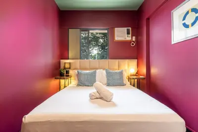 a bedroom with a large bed with purple walls at Boutique one-bedroom apartment near airport, business hubs in Manila