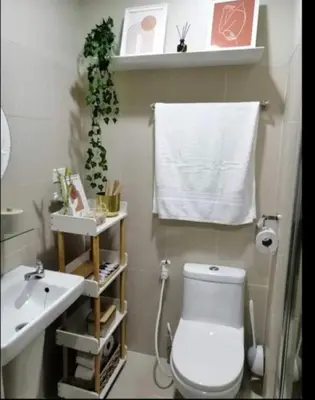 a bathroom with a white toilet and a sink at Vistaro Stays at Fame Residences in Manila