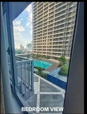a balcony with a view of a large building at Vistaro Stays at Fame Residences in Manila