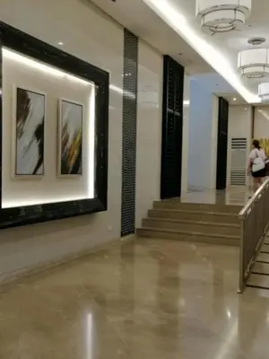a hallway with stairs and paintings in a building at Vistaro Stays at Fame Residences in Manila