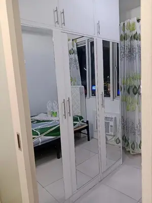 a room with glass doors with a bed in it at Sea Residence Tower A by Stave in Manila