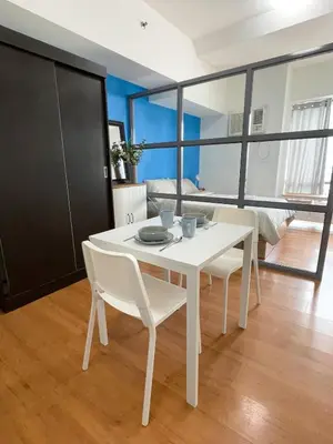 a dining room with a white table and chairs at 1 BR Condo in Manila near US Embassy & St Lukes in Manila