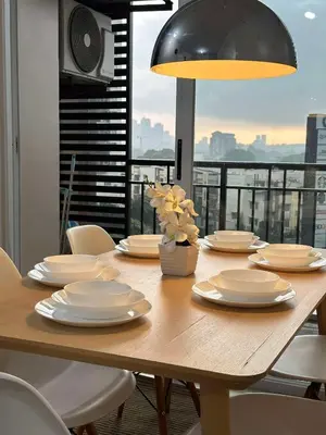 a wooden table with white dishes and a lamp at Circulo verde in Manila
