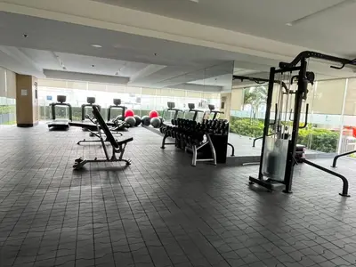 a gym with chairs and equipment in a building at Lush Residence in Manila