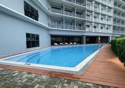 a swimming pool in front of a building at Lush Residence in Manila