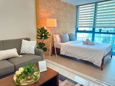 a living room with a bed and a couch at Chic 1-BR at Uptown BGC in Manila
