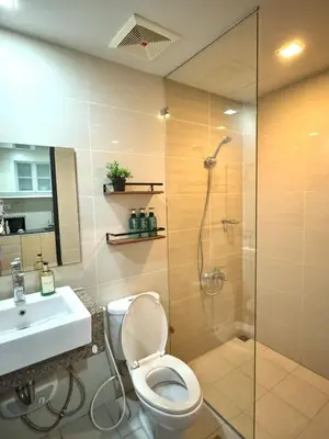 a bathroom with a shower and a toilet and a sink at Chic 1-BR at Uptown BGC in Manila