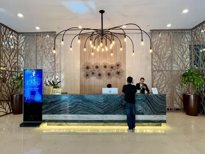 a man standing at a counter in a lobby at Chic 1-BR at Uptown BGC in Manila