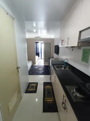 a small kitchen with a sink and a room at Derick's Place at Sea Residences in Manila