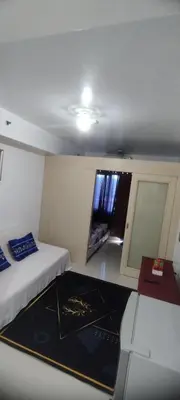 a room with two beds and a desk and a window at Derick's Place at Sea Residences in Manila