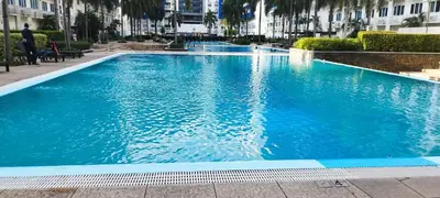 a large blue swimming pool in a building at Derick's Place at Sea Residences in Manila