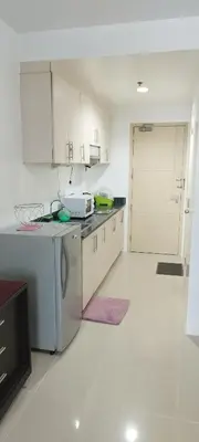 a kitchen with white cabinets and a white floor at Derick's Place at Sea Residences in Manila
