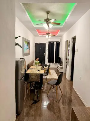 a man sitting at a dining room table in a living room at Santa Cosy Villa suite-B Fast Wi-Fi, Netflix Included Split system Air-con & Hot Shower Close to Enchanted Kingdom in Santa Rosa