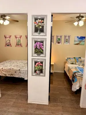 a room with two beds and flowers on a wall at Santa Cosy Villa suite-B Fast Wi-Fi, Netflix Included Split system Air-con & Hot Shower Close to Enchanted Kingdom in Santa Rosa