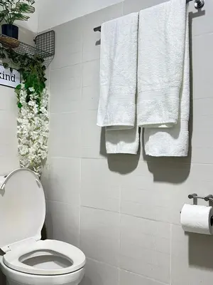 a bathroom with white towels hanging on a wall at A & M SUITE VACAY - Sea Residences Mall Of Asia Pasay in Manila
