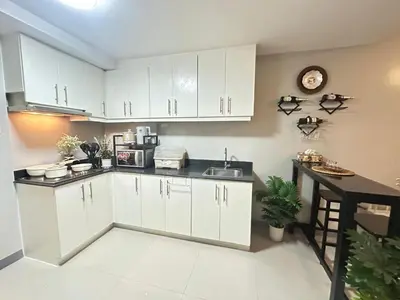 a kitchen with white cabinets and a counter top at A & M SUITE VACAY - Sea Residences Mall Of Asia Pasay in Manila