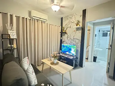 a living room with a table with a computer on it at A & M SUITE VACAY - Sea Residences Mall Of Asia Pasay in Manila