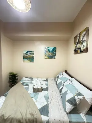 a bedroom with a large bed with posters on the wall at A & M SUITE VACAY - Sea Residences Mall Of Asia Pasay in Manila