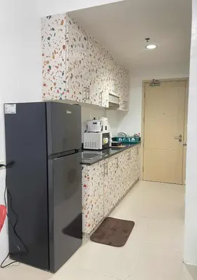 a kitchen with a black refrigerator in a room at Vonz Staycation Near Moa in Manila