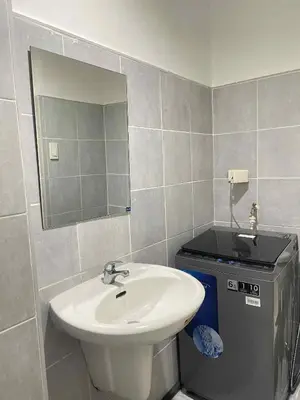 a bathroom with a sink and a mirror at Vonz Staycation Near Moa in Manila