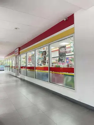 a store aisle with glass windows in a shopping mall at Vonz Staycation Near Moa in Manila