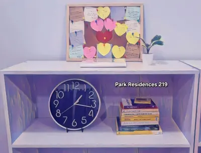 a clock sitting on top of a shelf with books at PARK RESIDENCE Unit 219, SM City Santa Rosa, Laguna, by SMDC in Ibaba