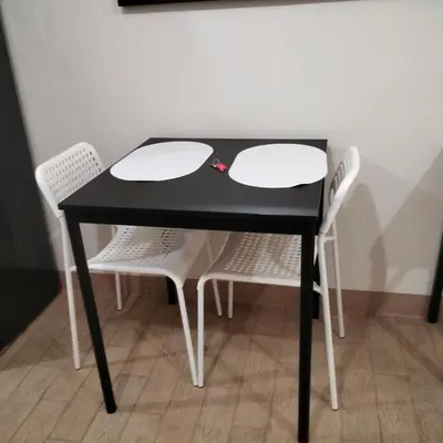 a black table with two white chairs around it at Cozy Gutz Place at 16th in Manila