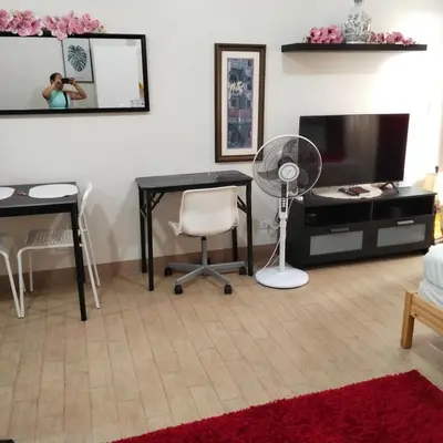 a living room with a desk and a table and a fan at Cozy Gutz Place at 16th in Manila