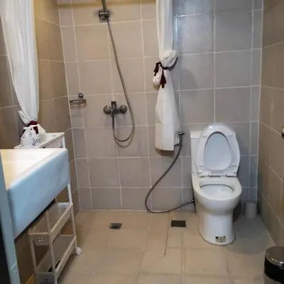 a bathroom with a shower and a toilet and a sink at Cozy Gutz Place at 16th in Manila