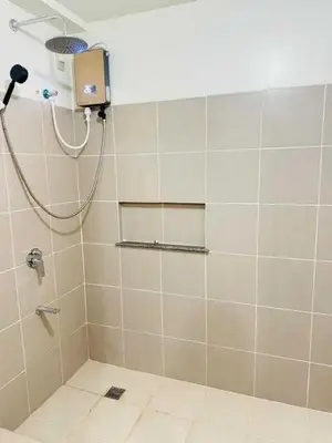 a bathroom with a shower with a shower at Vtan Condo in Manila