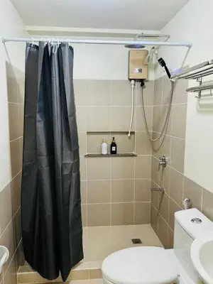 a bathroom with a shower curtain and a toilet at Vtan Condo in Manila