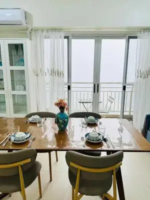 a dining room table with chairs and a vase on it at Vtan Condo in Manila