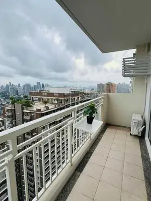 a balcony with a table and a view of a city at Vtan Condo in Manila
