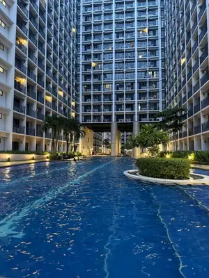 a large swimming pool in front of a large building at Cityscape staycation in Manila