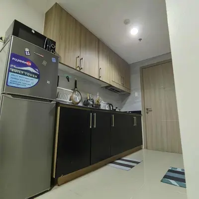 a kitchen with a stainless steel refrigerator and black cabinets at Cityscape staycation in Manila