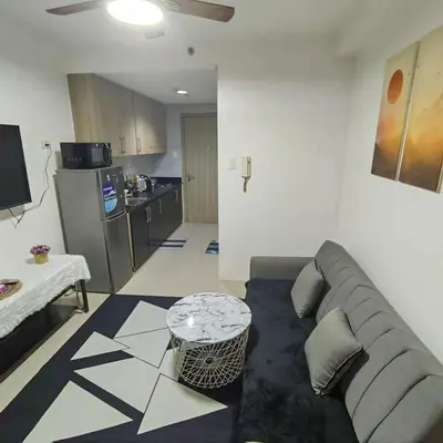 a living room with a couch and a kitchen at Cityscape staycation in Manila