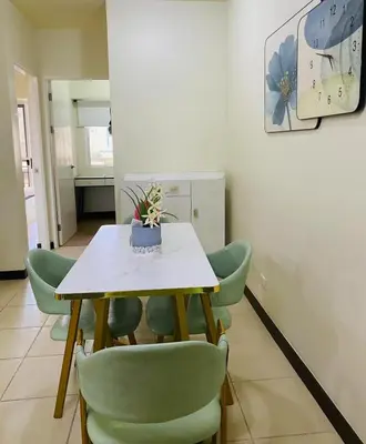 a dining room with a table and green chairs at Stan Condo in Manila