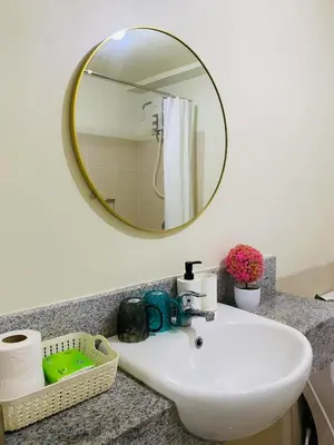 a bathroom with a white sink and a mirror at Stan Condo in Manila