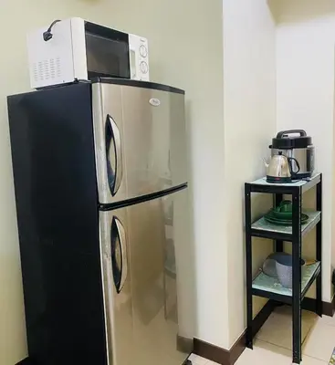 a microwave on top of a refrigerator in a kitchen at Stan Condo in Manila