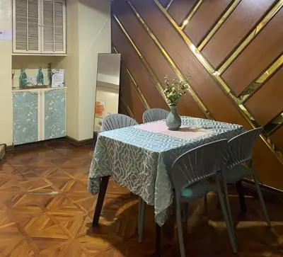 a table with a vase of flowers on it at Stan Condo in Manila