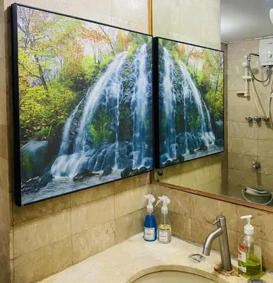 a bathroom with a large painting of a waterfall at Stan Condo in Manila