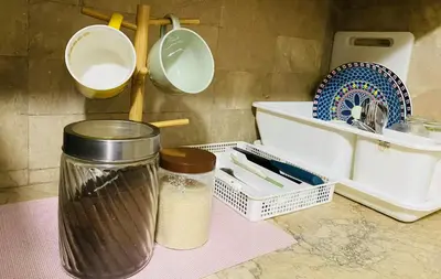 a kitchen counter with two jars and a sink at Stan Condo in Manila