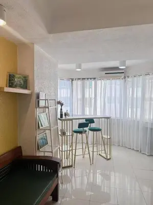 a living room with a table and stools at Stan Condo in Manila