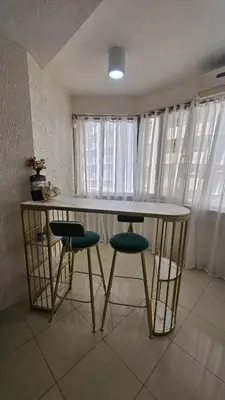 a kitchen with a table and stools in a room at Stan Condo in Manila