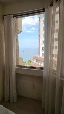 a window with a view of the ocean from a building at Stan Condo in Manila