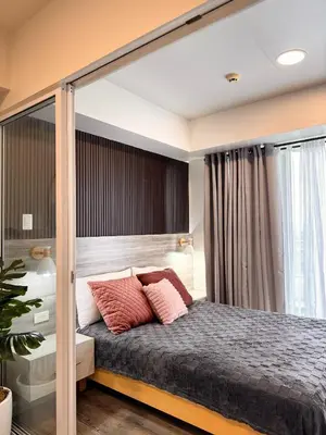 a bedroom with a large bed with pink pillows at Azure Urban Resort Residences in Manila