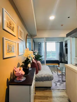 a room with a bed and a table with flowers on it at Azure Urban Resort Residences in Manila