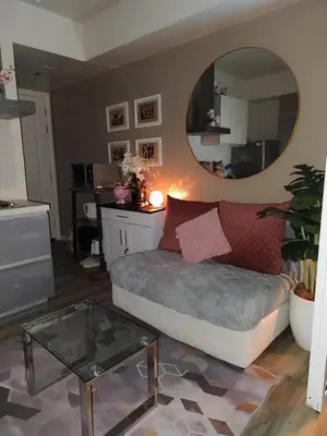 a living room with a couch and a mirror at Azure Urban Resort Residences in Manila